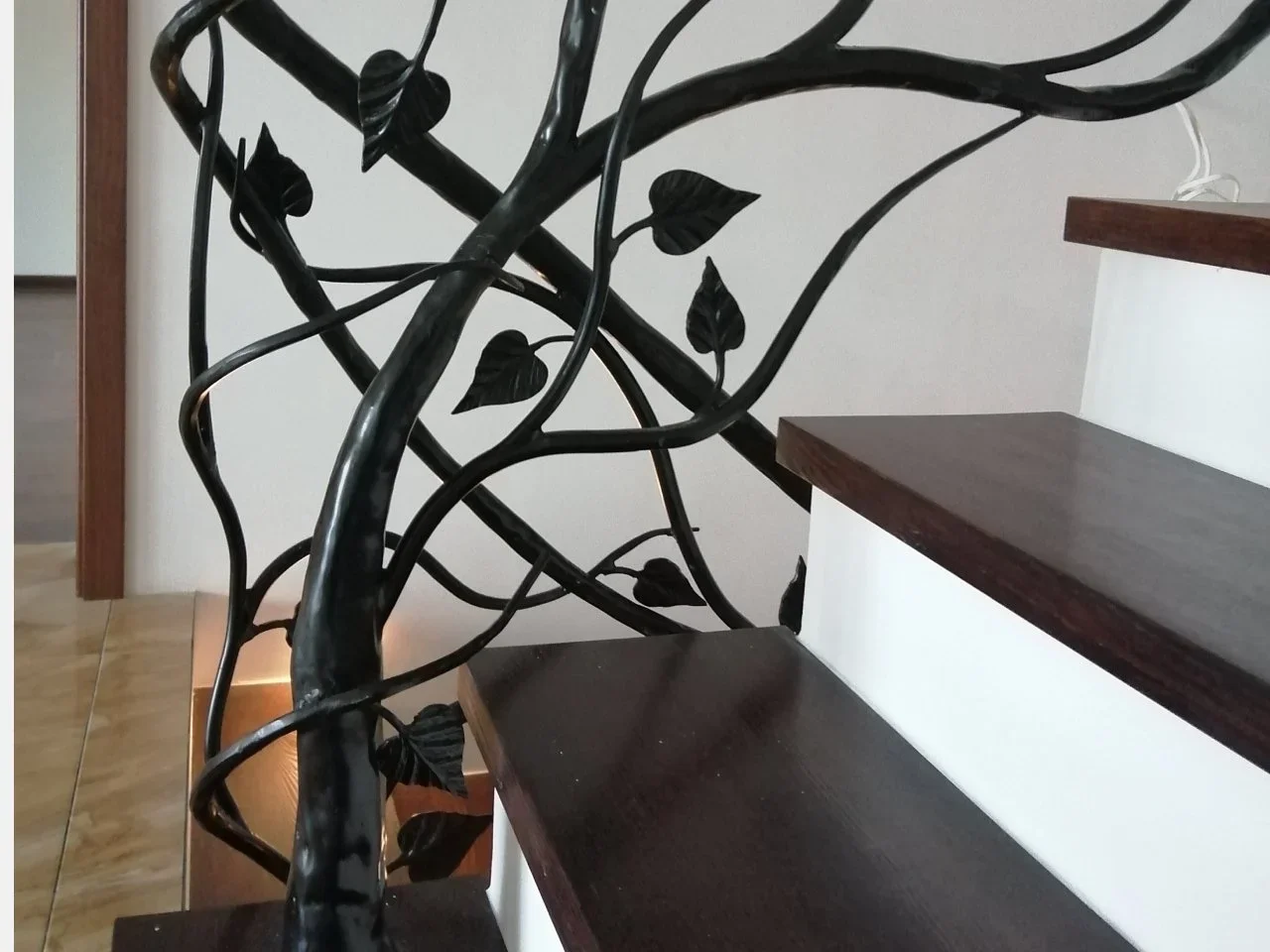 Artystyczne zakończenie poręczy kutej