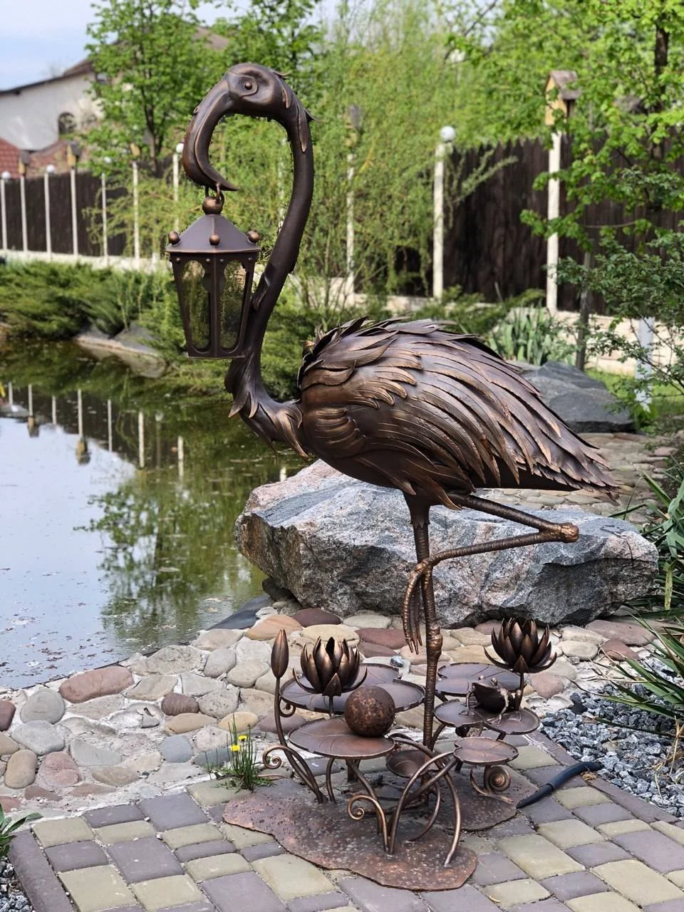 Lampa Flaming w ogrodzie nad stawem