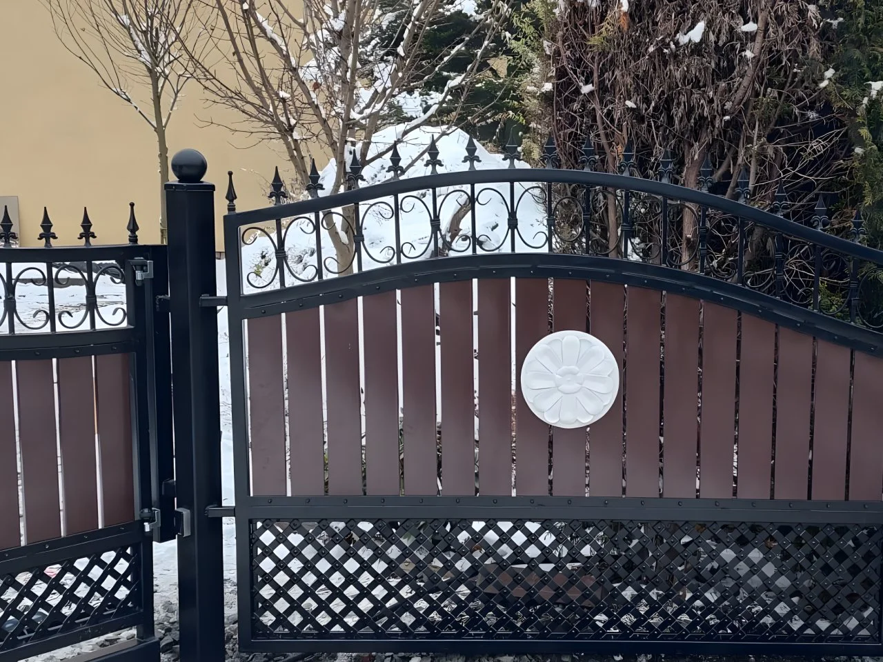 Nowoczesna brama kuta z panelami drewnianymi