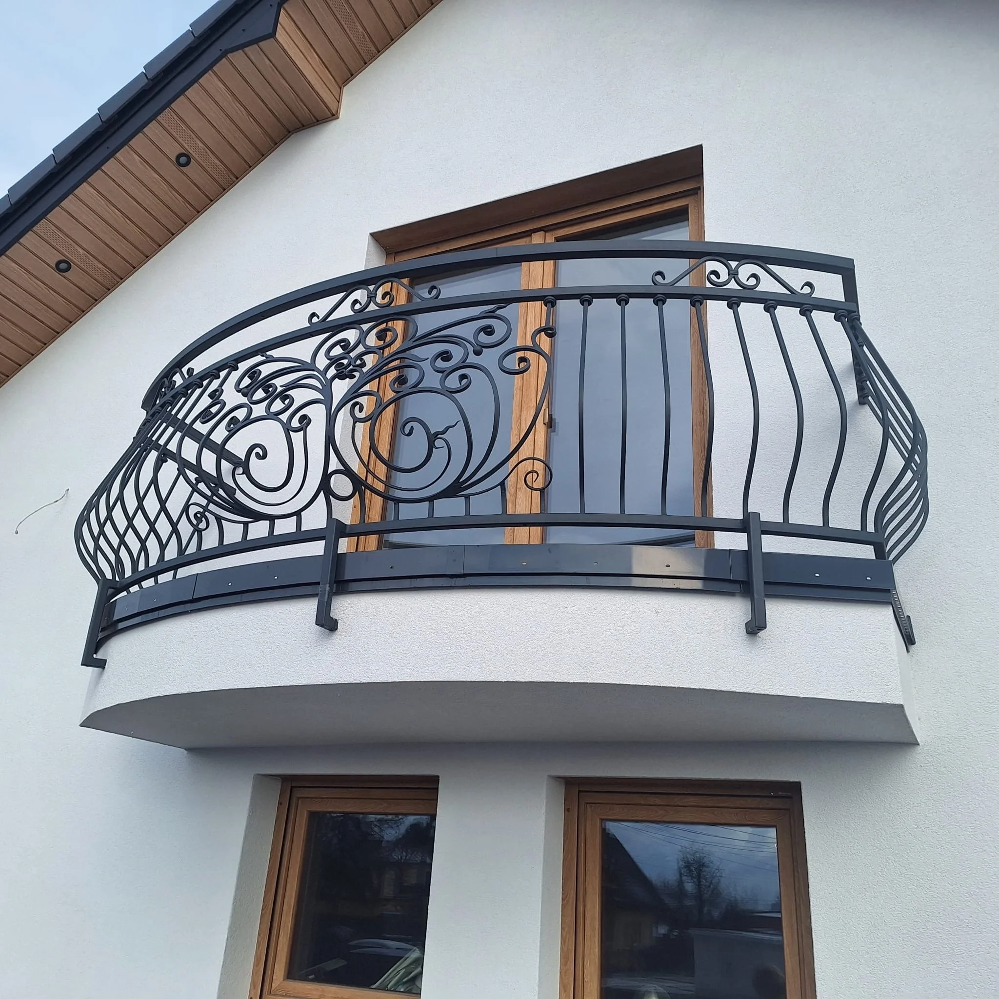 Półokrągła balustrada kuta z bogatym ornamentem